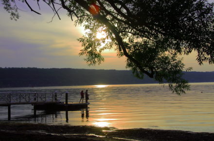 Couple on dock at Stewart Park, City of Ithaca at sunset