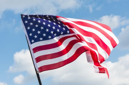 Low Angle View Of Stars And Stripes On American Flag Against Blu