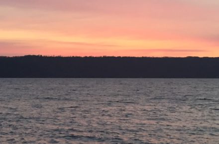 Sunrise On Cayuga Lake long view of lake and east shoreline with the skyline pink and orange before sun comes up over horizon